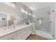 Modern bathroom featuring double vanity, walk-in shower with glass doors, and stylish gray tile at 1323 Stack Rd, Monroe, NC 28112