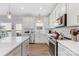 Bright kitchen featuring white cabinets, stainless steel appliances, with access to the back patio at 1323 Stack Rd, Monroe, NC 28112