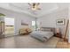 Spacious bedroom with tray ceiling, ceiling fan, neutral colors, large windows, and natural light at 1323 Stack Rd, Monroe, NC 28112
