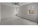This bedroom features neutral walls, carpet, a ceiling fan, and bright windows at 13701 Dawlish Ln, Pineville, NC 28134