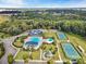 Aerial view of a community pool, tennis courts, clubhouse, and playground with lush trees at 13923 Jacks Ln, Pineville, NC 28134