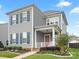 Charming two-story home boasts a red front door, inviting curb appeal and gray siding at 13923 Jacks Ln, Pineville, NC 28134