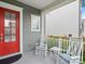 Inviting front porch with rocking chairs, cushions, and a red door offers a relaxing outdoor space at 13923 Jacks Ln, Pineville, NC 28134