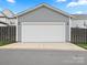 Spacious two-car garage featuring a white door, offering ample parking and storage space at 13923 Jacks Ln, Pineville, NC 28134