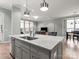 Kitchen island featuring a sink and a view into the living and dining areas at 13923 Jacks Ln, Pineville, NC 28134
