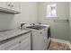 Functional laundry room with modern washer and dryer, complemented by granite countertop and white cabinetry at 13923 Jacks Ln, Pineville, NC 28134