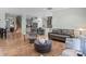 Open-concept living room featuring hardwood floors, gray kitchen, and comfortable seating arrangements at 13923 Jacks Ln, Pineville, NC 28134