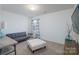 A spacious and empty room featuring an ottoman, couch and window with curtains at 203 Waterlemon Way, Monroe, NC 28110