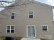 Back exterior with multiple windows and sliding glass door leading to a concrete patio and grill at 203 Waterlemon Way, Monroe, NC 28110