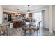 Eat-in kitchen featuring dark wood cabinets, stainless steel appliances, and a glass-top dining table at 203 Waterlemon Way, Monroe, NC 28110