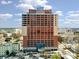 Exterior view of the Hyatt Place Hotel Building with brick and gray trim under a blue sky and clouds at 222 S Caldwell St # 1803, Charlotte, NC 28202