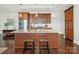 Well-lit modern kitchen boasts a large island with granite countertops and wood cabinets at 222 S Caldwell St # 1803, Charlotte, NC 28202