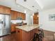 Bright kitchen featuring stainless steel appliances, a granite island, and wood cabinetry at 222 S Caldwell St # 1803, Charlotte, NC 28202