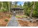 Beautiful home with a stone fire pit, benches, and gravel pathways in a lush backyard setting at 231 Sunny Path Ln, Statesville, NC 28677