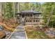 Beautiful exterior view of elevated modern home with black roof and patio in a wooded area at 231 Sunny Path Ln, Statesville, NC 28677