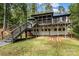 Exterior view featuring a modern home design with a deck, staircase, and yard with cornhole game at 231 Sunny Path Ln, Statesville, NC 28677