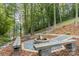 Outdoor fire pit area with stone benches and a view of the lake, creating a cozy space for relaxation at 231 Sunny Path Ln, Statesville, NC 28677