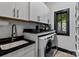 Laundry room with white cabinets, black countertops and stainless steel appliances at 231 Sunny Path Ln, Statesville, NC 28677
