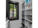Organized pantry with white shelving, storage baskets, and a window offering a glimpse of the outdoors at 231 Sunny Path Ln, Statesville, NC 28677