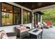 Cozy covered porch showcasing comfortable seating, a fire table, and serene views of the surrounding greenery at 231 Sunny Path Ln, Statesville, NC 28677