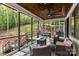 Inviting covered porch with wood ceiling, outdoor furniture, and views of the lush, green landscape at 231 Sunny Path Ln, Statesville, NC 28677