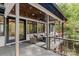 Relaxing covered porch featuring comfortable seating, wood ceilings, and scenic views of the backyard at 231 Sunny Path Ln, Statesville, NC 28677
