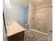 Bathroom featuring a stone-tile floor, wooden vanity, and glass-enclosed shower at 234 Pointe Cir, Rock Hill, SC 29732