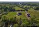 Aerial view of new construction home surrounded by lush green grass and trees, including other neighborhood homes at 2355 Emanuel Church Rd, Rockwell, NC 28138