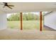 Covered back porch with a ceiling fan and wooden decking overlooks the lush green yard and distant trees at 2355 Emanuel Church Rd, Rockwell, NC 28138