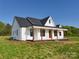 Exterior elevation of new construction farmhouse featuring a dark roof, white siding, and wood beam porch at 2355 Emanuel Church Rd, Rockwell, NC 28138