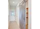 Hallway features a decorative barn door, wood-look flooring, and a bright white door with glass panes at 2355 Emanuel Church Rd, Rockwell, NC 28138