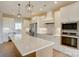 Bright kitchen with white cabinets, stainless steel appliances, an island with quartz countertop and modern pendant lighting at 2355 Emanuel Church Rd, Rockwell, NC 28138