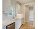 Well-lit kitchen with a farmhouse sink, stainless steel dishwasher, white cabinets, and quartz countertops at 2355 Emanuel Church Rd, Rockwell, NC 28138