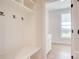 Mud room boasts built in bench, cubbies, and hooks next to an open doorway and view of window at 2355 Emanuel Church Rd, Rockwell, NC 28138