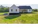 Rear exterior of new construction farmhouse featuring a dark roof, white siding, and wood beam porch at 2355 Emanuel Church Rd, Rockwell, NC 28138