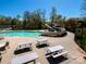 Community pool with waterslide, lounge chairs, picnic tables, and surrounded by lush trees at 2517 Trading Ford Dr, Waxhaw, NC 28173