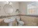 Charming powder room with pedestal sink, decorative tile, and a bright window at 252 Legend Dr, Rock Hill, SC 29732