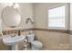 Stylish powder room featuring decorative tile work, pedestal sink, and ample natural light at 252 Legend Dr, Rock Hill, SC 29732