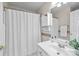 Well-lit bathroom featuring a white vanity, decorative mirror, and a shower with a white curtain at 252 Legend Dr, Rock Hill, SC 29732