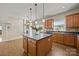 Kitchen island with pendant lights over dark countertops, wood cabinets, and hardwood flooring at 252 Legend Dr, Rock Hill, SC 29732