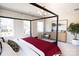 Well-lit bedroom featuring a four-poster bed, natural lighting, and neutral carpeting at 305 Old Town Village Rd, Waxhaw, NC 28173