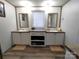 Bathroom with double vanity, mirrors, storage shelves, and shiplap walls at 404 B And S Ln, Hickory, NC 28601