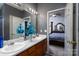 Stylish bathroom with double sinks, wooden vanity, and decorative blue floral arrangement offers a practical space at 4213 Devonbridge Ln, Charlotte, NC 28269