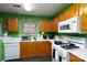 Functional kitchen with oak cabinets, laminate countertops, and appliances overlooking the dining area at 4213 Devonbridge Ln, Charlotte, NC 28269