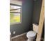 A bathroom featuring a toilet, gray walls, and a small window at 504 Elizabeth Dr, Gastonia, NC 28052