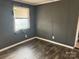 A bedroom with gray walls, a window with blinds, and wood-look flooring at 504 Elizabeth Dr, Gastonia, NC 28052