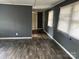 An empty living room with gray walls, wood-look flooring, and natural light at 504 Elizabeth Dr, Gastonia, NC 28052