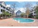 Community pool surrounded by brick patio and buildings at 525 N Graham St # 2F, Charlotte, NC 28202