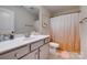 Well-lit bathroom with a white vanity, tiled floor, and peach-colored shower curtain at 5431 Meadowcroft Way, Fort Mill, SC 29708