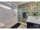 Bathroom featuring shower with glass door and sink with botanical wallpaper accent wall at 5431 Meadowcroft Way, Fort Mill, SC 29708